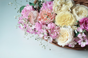 English roses in basket on neutral background