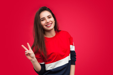 Pretty girl showing two fingers on red