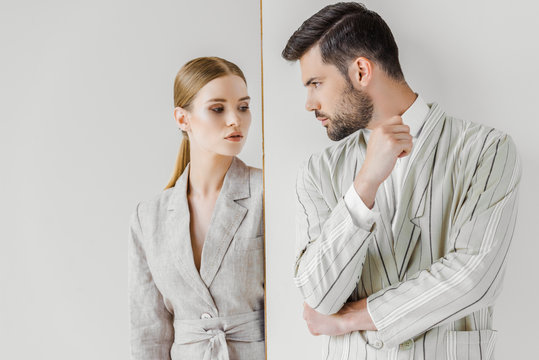 passionate young male and female models in vintage jackets looking at each other on white