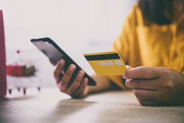 Image of Young woman using smartphone for online shopping website and pay by credit card, Online payment and shopping concept