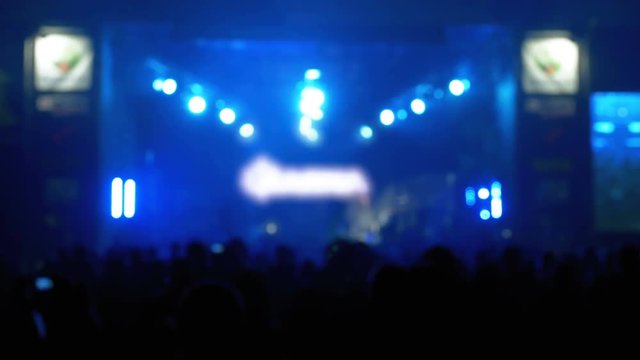 Blurred Concert Crowd at Music Festival. Crowd people dancing Rock concert, weighed, applauds, raises his hands up and photographed, filmed concert on the phones and smartphones. Party People In