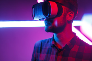 Casual man in VR glasses in neon
