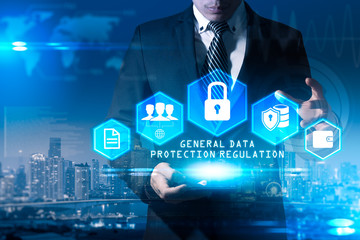 The abstract image of the business man hold the GDPR hologram on hand and overlay with cityscape image. the concept of data, communications, privacy, internet of things and GDPR.