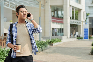 Fototapeta premium Young man with smartphone and coffee cup