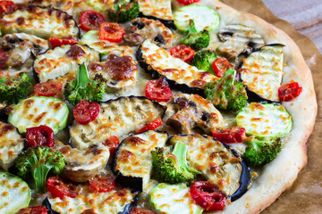 Homemade pizza with vegetables, natural dough on leaven. With zucchini, eggplant, cherry tomato, broccoli, mushrooms. The concept of a healthy diet. Vegetarian.