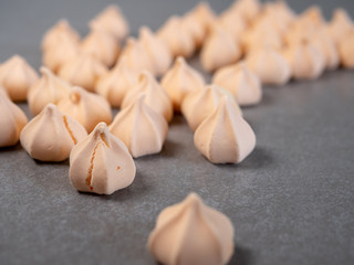 Colorful meringues, arranged on grey background
