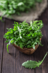Obraz na płótnie Canvas Fresh green arugula in bowl on table. Arugula rucola for salad. Close up of fresh green healthy food. Diet concept