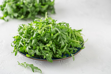 Fresh green arugula in bowl on table. Arugula rucola for salad. Close up of fresh green healthy food. Diet concept