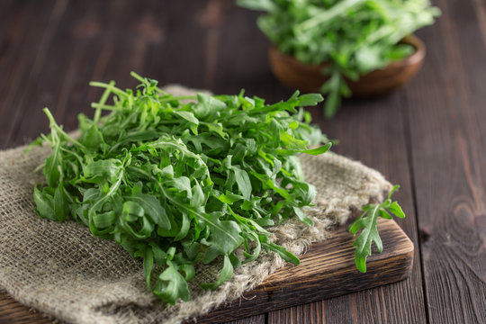 Fresh green arugula in bowl on table. Arugula rucola for salad. Close up of fresh green healthy food. Diet concept