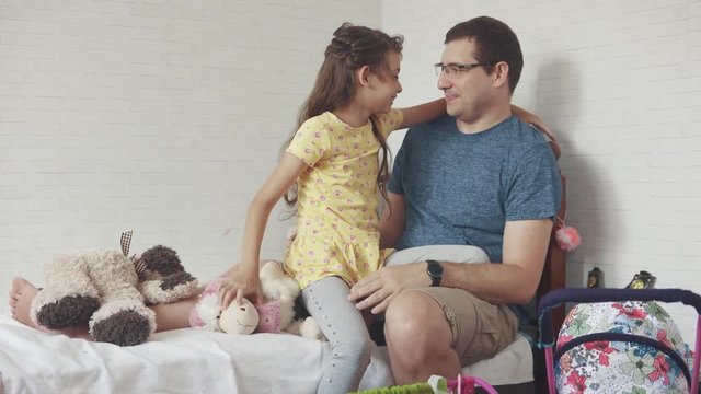 The young father and daughter play together in the children's room. the girl hugs her father