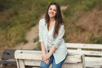 Portrait of a young girl with long dark hair in a blue shirt and jeans.