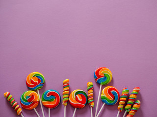 colorful candies on purple background, top view, place for text, can eb use as greeting card