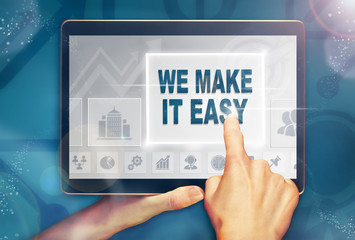 A hand selecting a We Make It Easy business concept on a computer tablet screen with a colorful background.