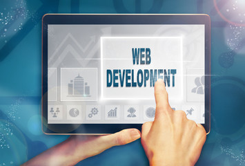 A hand selecting a Web Development business concept on a computer tablet screen with a colorful background.