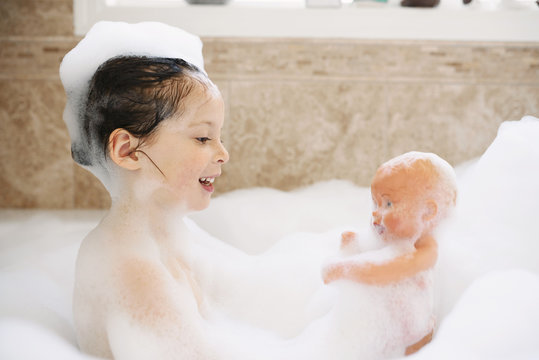 Young girl playing in a bubble bath