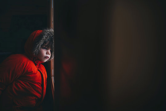 Boy wearing a winter jacket standing by the front door