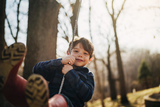 Portrait of boy playing on rope swing