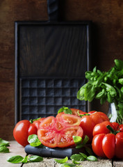 Large red tomatoes on vintage wooden table, selective focus
