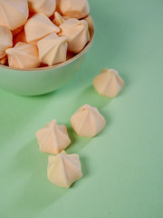 Colorful meringues in a mint green bowl