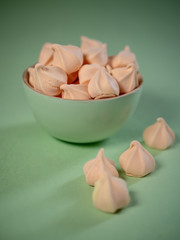 Colorful meringues in a mint green bowl