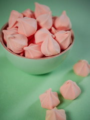 Colorful meringues in a mint green bowl