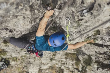 Foto op Canvas Van bovenaf foto van een man alpinist die een rots beklimt. © LStockStudio
