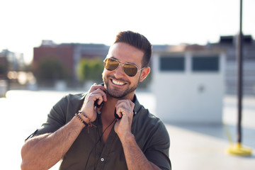 Happy trendy young caucasian man outdoors portrait