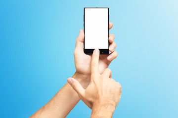 Mockup of male hand holding frameless cellphone and swiping blank white screen isolated at blue background.