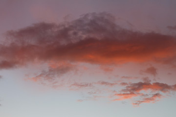Sky clouds background. Cumulus pink red clouds in the sunset. Color clouds in the evening. Sky with a pastel colored background
