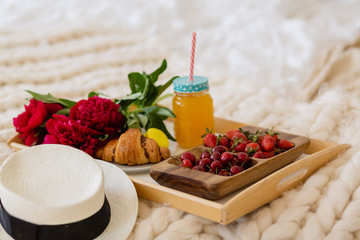 breakfast in bed with coffee, croissants, strawberries and juice