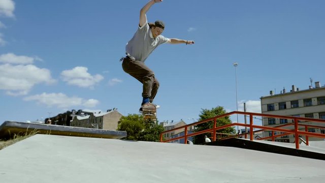 Young skater doing tricks outdoors. Slowmotion video 150fps