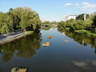 flight over the river in a city park among trees