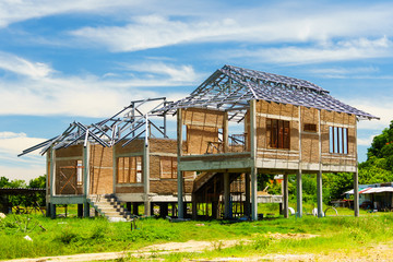 New residential construction house framing against a blue sky ans green forest