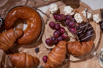 Still life, food and drink concept. Romantic dinner with croissants, fruits and champagne. Selective focus. Top view, flat lay