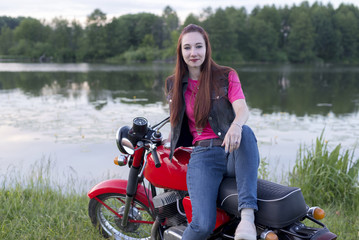 Fototapeta na wymiar Girl sitting on a vintage motorcycle outdoors