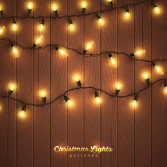 Yellow christmas lights on wooden background