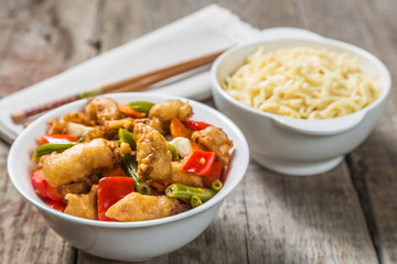 Deep-fried squid with vegetables in garlic sauce with noodles. Concept of Chinese cuisine. 