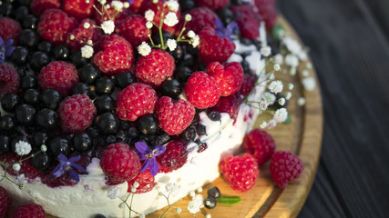 Cheese cake with currant and raspberries on a black background