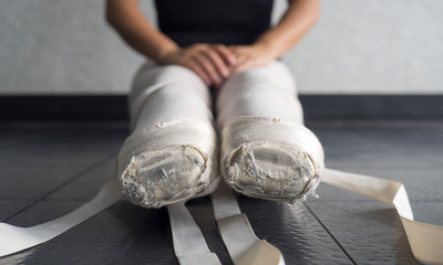 Ballet pointe shoes on a young female ballerina untied in ballet class  © Katherine BYC