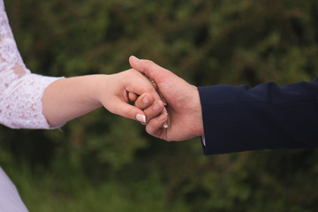Bride and groom holding hands outdoors