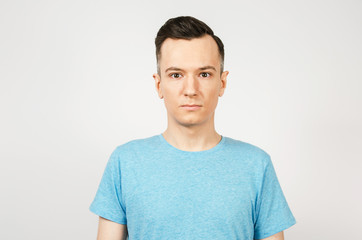 Young guy dressed in a blue t-shirt on a light background.