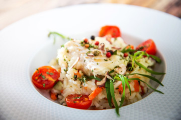 Cooked rice with vegetables, cod and lemon sauce