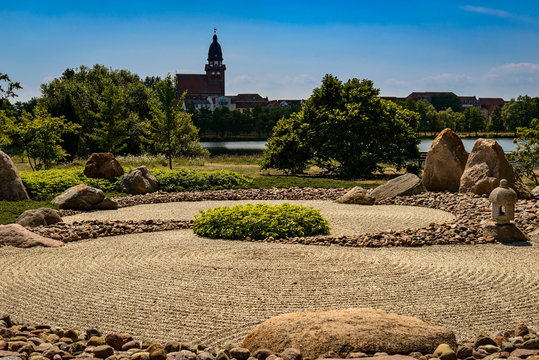 Japanischer Zen-Garten am Ufer des Tiefwarensees, im Hintergrund die Kirche St. Marien