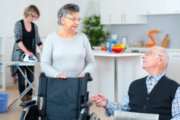 senior couple at home with carer helping out