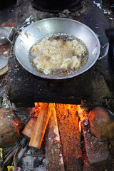Frying tempeh in a steel pan and a traditional stove