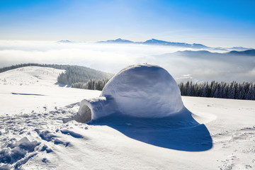 Marvelous huge white snowy hut, igloo  the house of isolated tourist is standing on high mountain...