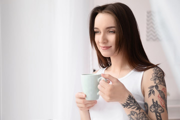 Young beautiful woman drinking coffee at home in morning