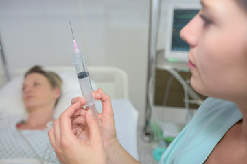 physiotherapist injecting female patient in clinic