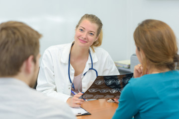 Female doctor talking to young couple