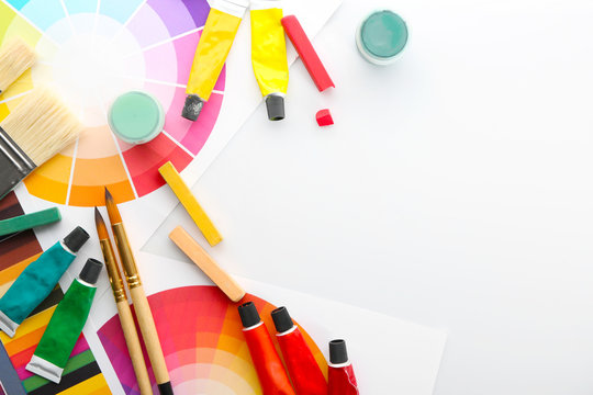 Painter's supplies with color samples on white background